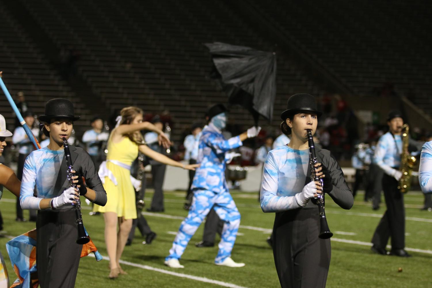 Sophomores Lauren Thomason and Brooke Fertig perform one of their routines during halftime, with marching band and color guard.