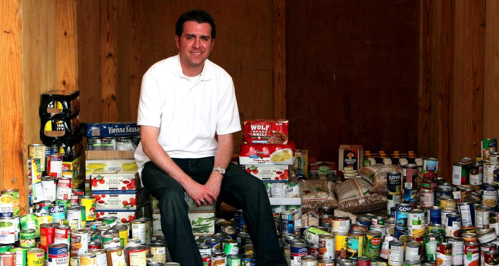 World History and US History teacher, Alejandro Garcia happily sits upon his ‘new record setting pile of cans’. A total of 1,605 cans were collected by the efforts of his class periods as well as other campus help for the food drive.
