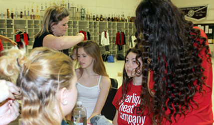 Theatre Arts teacher and STC director Kayln Holloway (top left) helps get the cast ready for their big performance. The cast does each other’s hair and makeup while listening to 30’s music in order to prepare for the time period show.