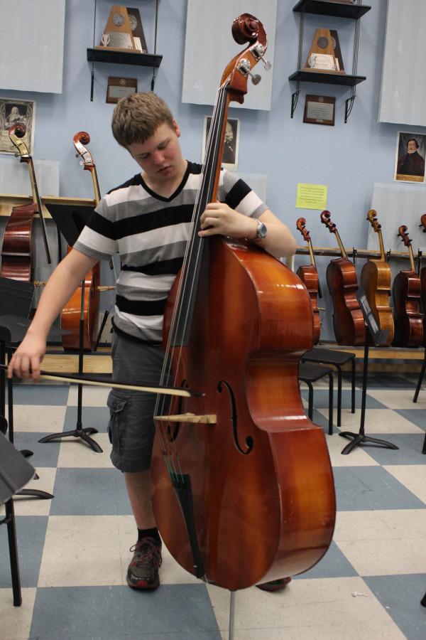 Junior Ty Tuttle practices a song on the stand-up bass.  Tuttle has been in orchestra playing the stand-up bass for three years.