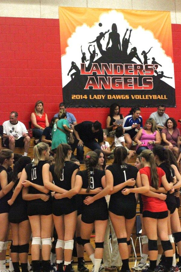 Landers Angels: Varsity volleyball players huddle together with their new coach Vicki Benson.  The 2014 Lady “Dawgs volleyball season is dedicated to former coach Jason Landers who passed away this summer. Photo by Jasmine CorreaLanders Angels: Varsity volleyball players huddle together with their new coach Vicki Benson.  The 2014 Lady “Dawgs volleyball season is dedicated to former coach Jason Landers who passed away this summer. Photo by Jasmine Correa