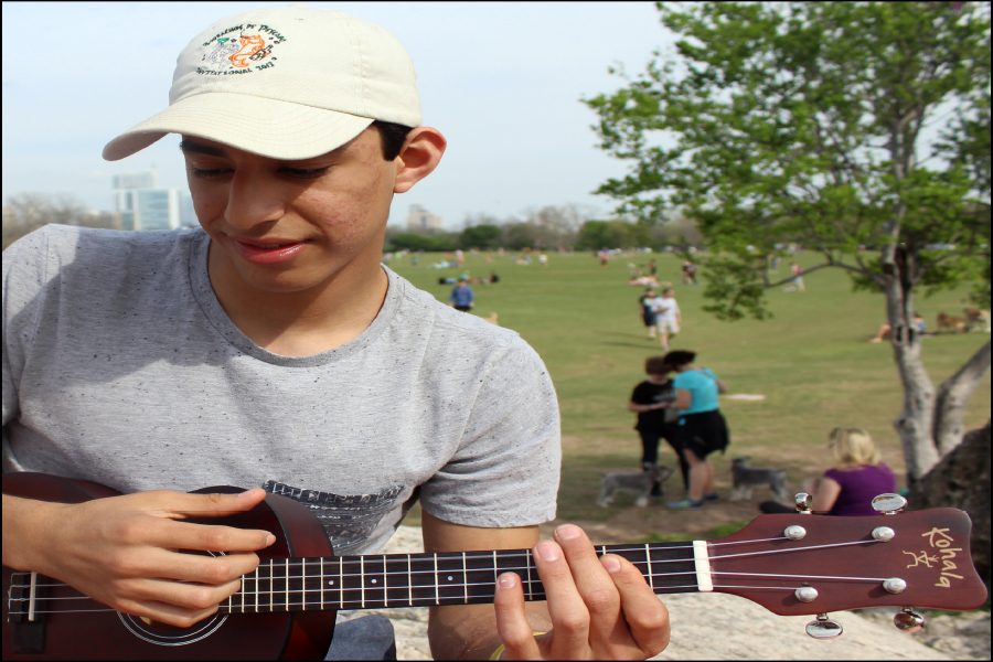 Strumming a note, sophomore Chris Lomeli plays at Zilker Park for friends. He spends most of his free time writing songs and experimenting with music on string instruments like the ukulele.