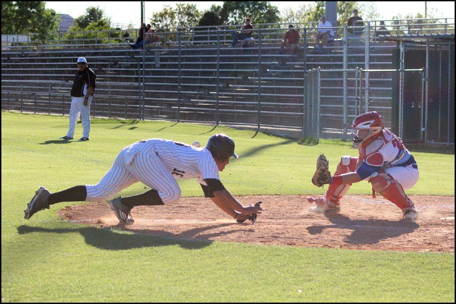 Senior Chris Alanis slides into the home base. As one of his teammates had just hit the ball to the outfield, Alanis took the opportunity to run from second base to home and barely made it safe as the Hays catcher was prepared to tag him out. 