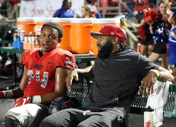 PROFESSIONAL ADVICE: Carolina Panthers NFL player Michael Grif n talks to junior running back Kyle Carter during the varsity versus Vista Ridge football game. According to Carter he was told, ‘You’re capable of doing big things and if you run through your tackles you’ll be unstoppable’ by Griffin.