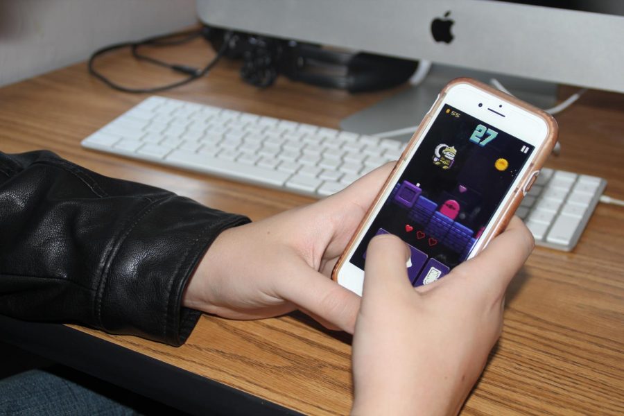 HIGHSCORE: Sophomore Liam Connally attempts to beat his own high score on Hoppenhelm, a free game available on the app store. The addictive game leads players through a dungeon, collecting coins, fighting monsters to reach a new high score.