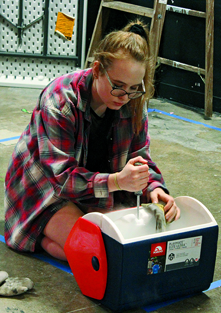 STAGE MANAGING: Alyssa Shumaker breaks dry ice for the fog machine. The machine was used to add suspense in Violet Sharp policemen and a dead baby in the woods.