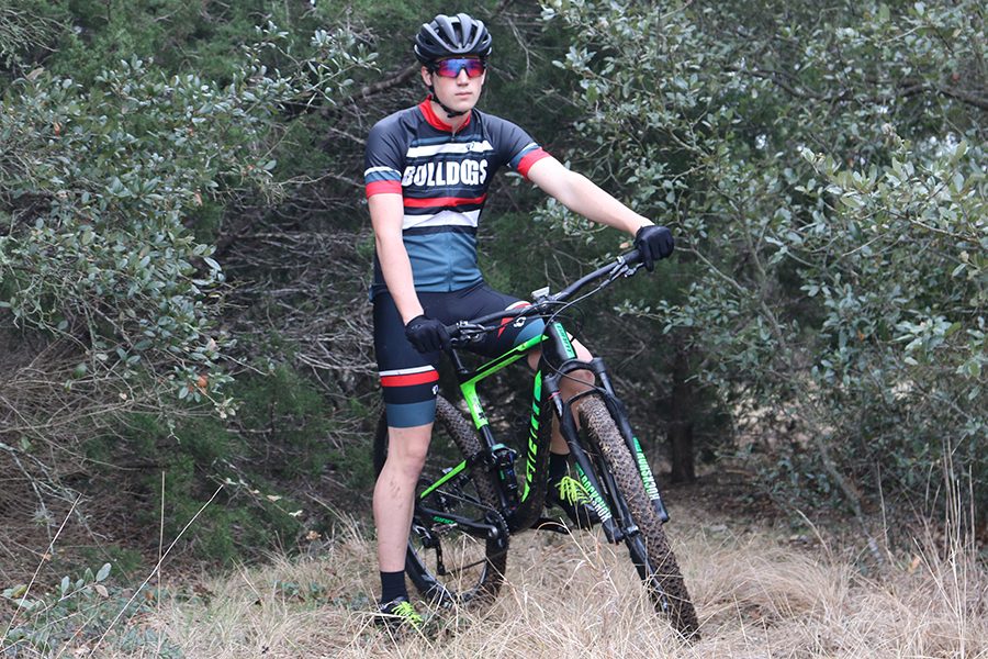 PICTURE PERFECT : While in his Bowie mountain biking uniform junior Austin Buttlar stops for a quick picture with his bike on the trails of Circle C. Buttlar plans to continue biking in college and hopes to have a job that involves biking of some sort.