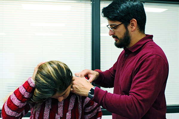 ZAP: Sports trainer Pablo Riera applies an electrical stimulation pad on senior Aylen Vivar. Trainers help prevent, diagnose and rehabilitate injuries.