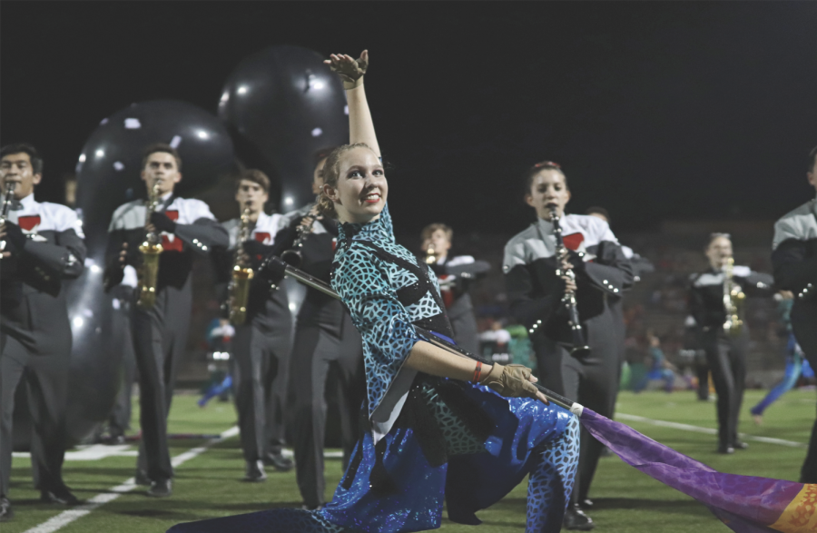 FLEXING ON THE FIELD: Sophomore Emma Taylor shows off her skills during a Bowie football game. Taylor and the girls are planning to travel to Beijing in May for Winter Guard International. 