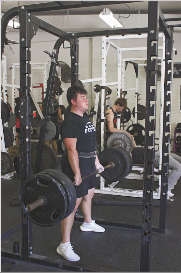 WEIGHT OF THE WORLD: Junior Evan Janacek dead-lifts in the weight room. Janacek has been dedicating hours weekly to the sport. 