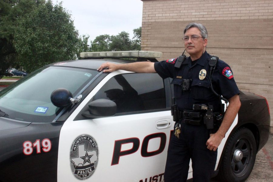 HEIGHTENED ATTENTION: Police officer Steven Melton surveils the parking lot as students leave for the weekend. A school threat on April 15 has enhanced the presence of security.