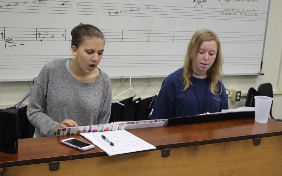 REHEARSING: Sophomores Kaelie Douglass and Carson Haley sit at the piano and rehearse their songs for the choir region competition.