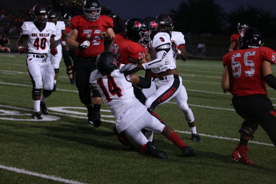 The varsity team tries to get the ball through Del Valles defense. The play ended with a tackle, and the ball falling.