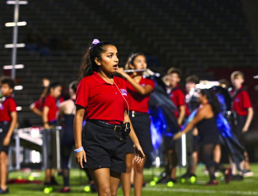 LOUD AND TUNEFUL: In the half-time performance, senior Hannah Cherukuri sings in The Apotheosis. Cherukuri had to focus on her volume to make sure everyone in the audience could hear her vocals while the band was playing right behind her.