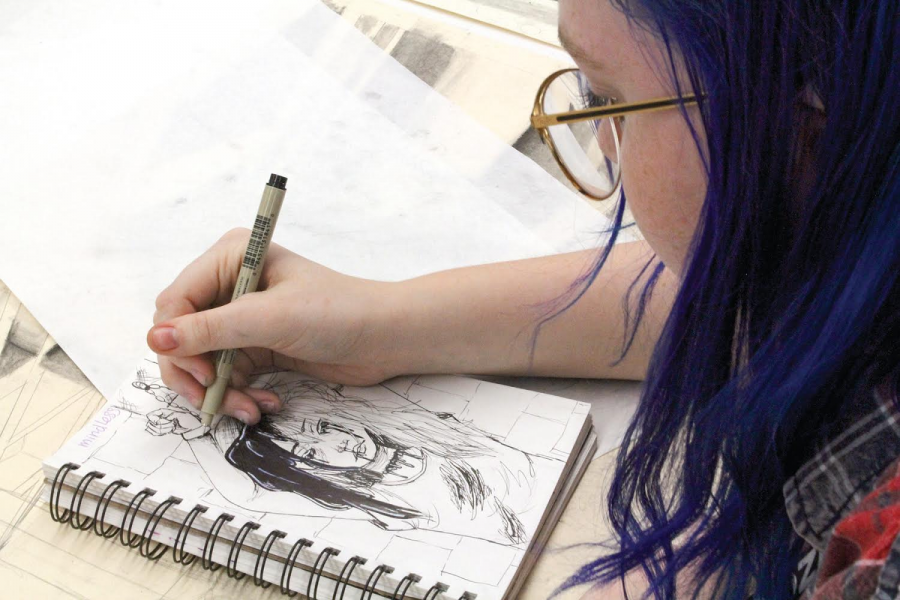 CREATIVE AND DETERMINED: In her art class, freshman Abby Carlson, draws a symbolic picture of a girl with her hands tied. The prompt for this drawing was “mindless” and her work was solely based on her creativity.
