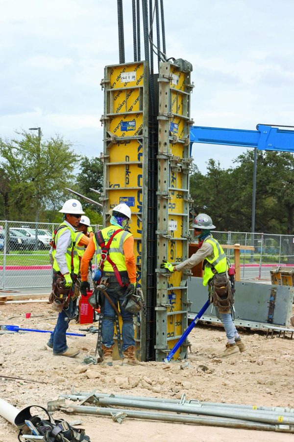TOTAL TEAMWORK: Construction workers set up a concrete form for a column. Columns are poured on top of underground piers.