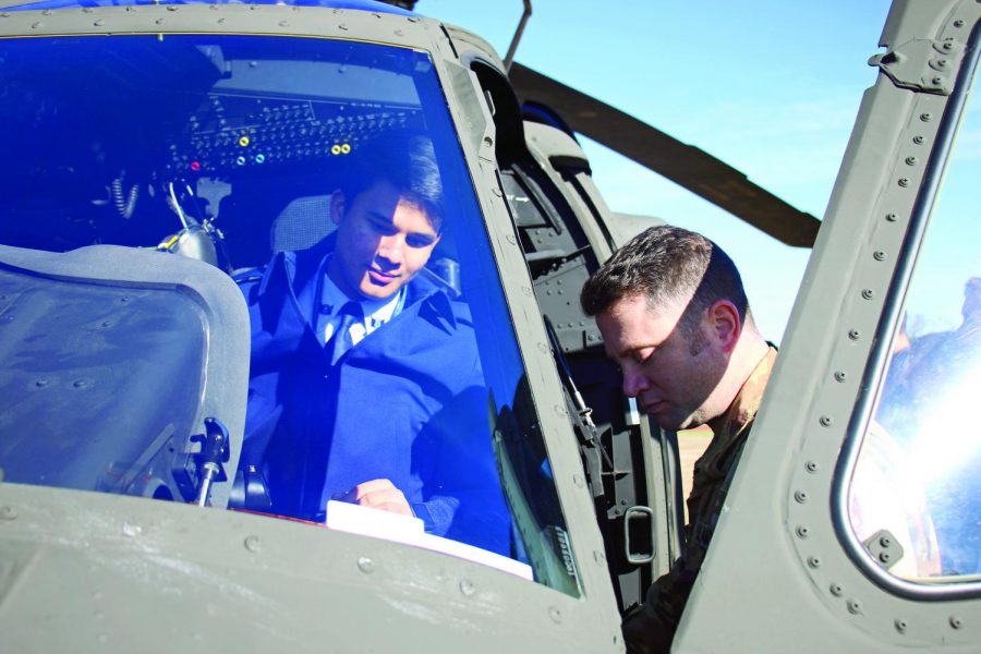 HANDS ON: Chief Warrant Officer Billy Black shows senior Walter Esparza the helicopter flight controls. Black was a cadet in JROTC when he attended Bowie. 