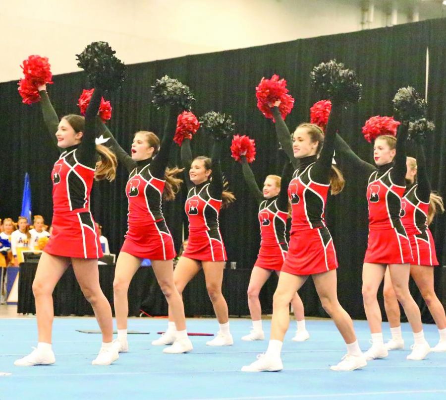 SCHOOL SPIRIT: The JV team performs their routine for a panel of judges. The judges critique each team’s technique, routine difficulty, and stunt quantity to determine scores. 