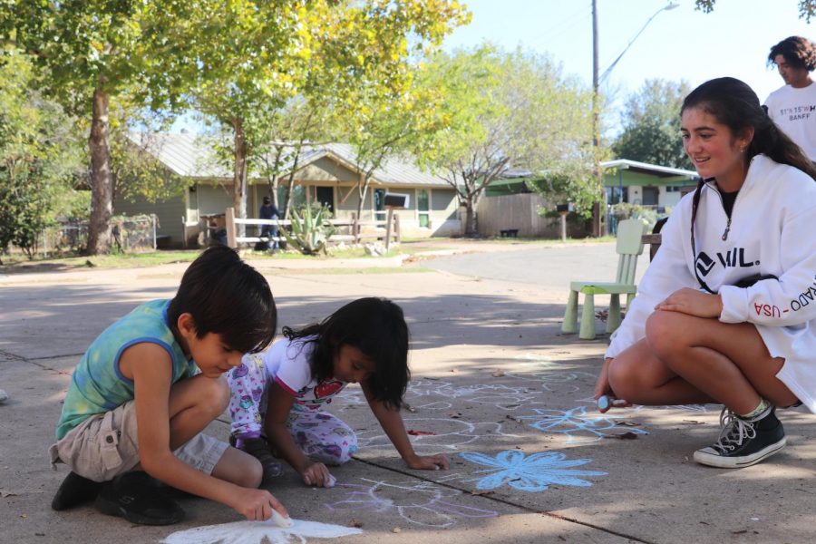 Sophomore Cristina Canepa laughs alongside two children as they paint the sidewalk with chalk. When a student under 18 volunteers at the family shelter, they must have an adult present. *Identities of the non-high school students have been withheld for privacy reasons.