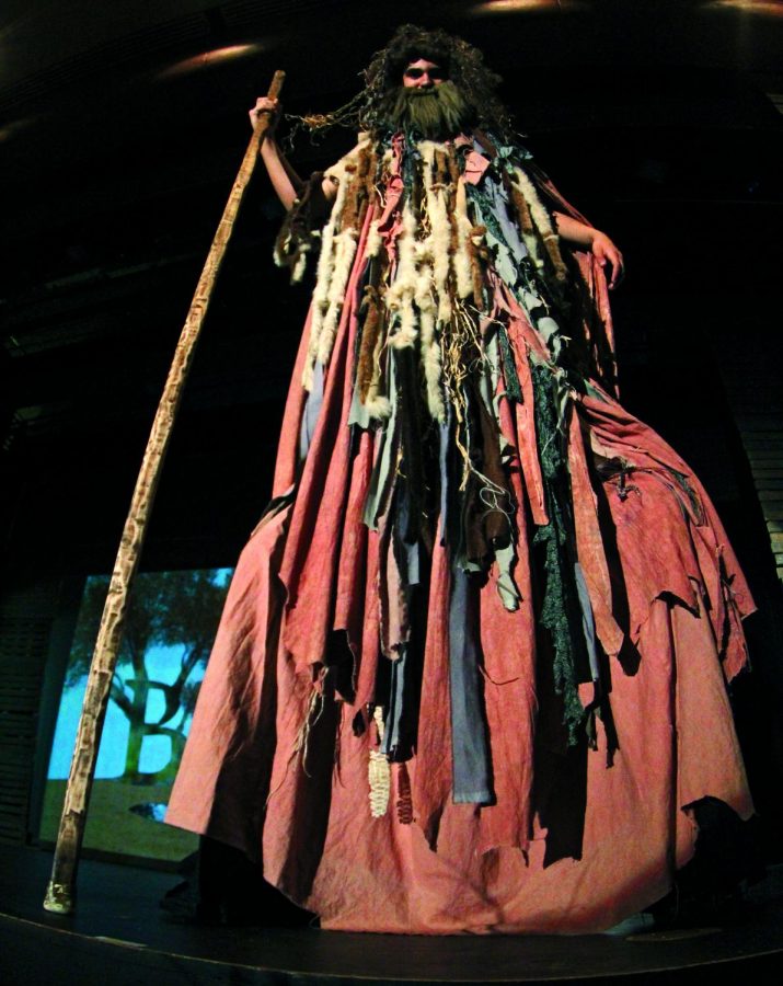 HIGH AND MIGHTY: Javier Lozano stands straight, balancing on his stilts with his staff. For many weeks, Lozano would practice walking up and down aisles in the theatre in order to be prepared. 