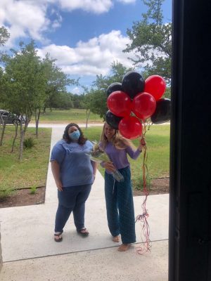 Senior Ava Nielsen stands outside of her house with the Student Council sponsor Kaylin Brett, who gave her balloons and flowers. The student council also wrote Nielsen a letter congratulating her on her win. 
