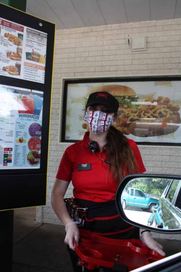 Junior Brooke Forsyth poses for a photo while working a shift at Sonic. Under Texas Governor Greg Abbott and Austin Mayor Steve Adler’s orders, essential businesses such as restaurants like Sonic will remain open during quarantine but must follow social distancing policies.