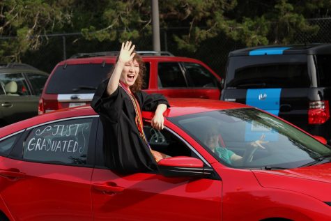 Senior Elizabeth Cluchey beams as she waves to her beloved teachers. Cluchey said that upon reflection of her high school career, it would be the family she had in the Starlight Theatre Company that she will miss the most.