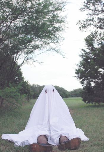 SPOOKY AND TRENDY: Senior Faith Lawrence sits on the grassy
field as she gets her picture taken for the ghost photo shoot. The
hashtag ghostphotoshoot has over 3.1 billion views on TikTok.