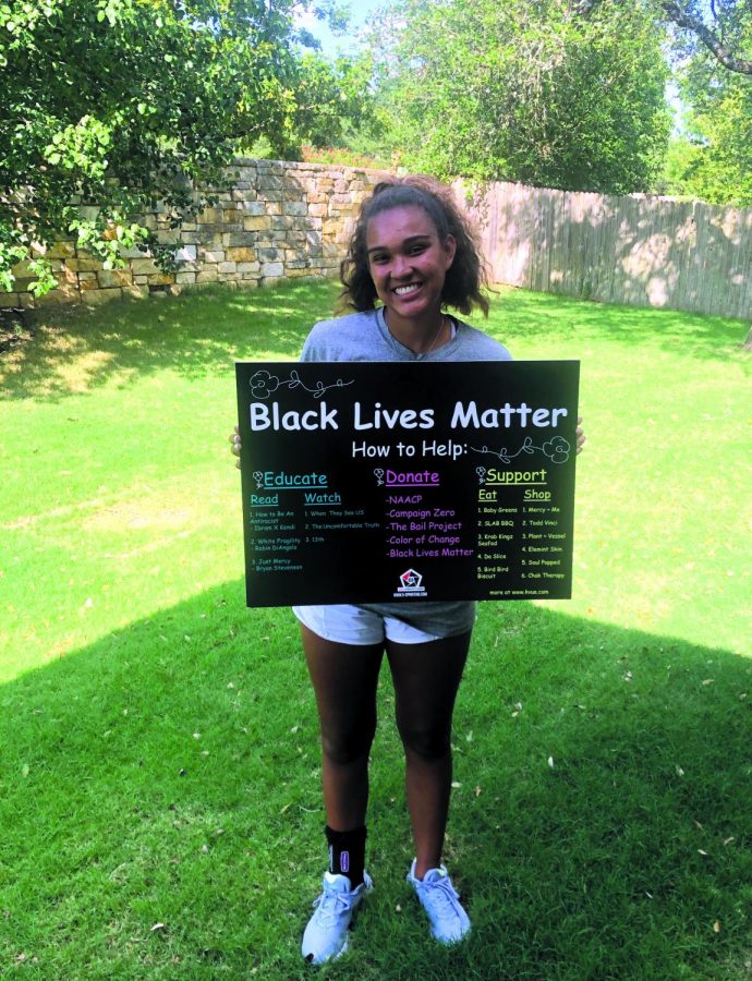 SIGN IN HAND: Smiling with her sign, senior Vivian Howard shows off her creative work. Howard created the sign last summer to help educate on the Black Lives Matter movement. 