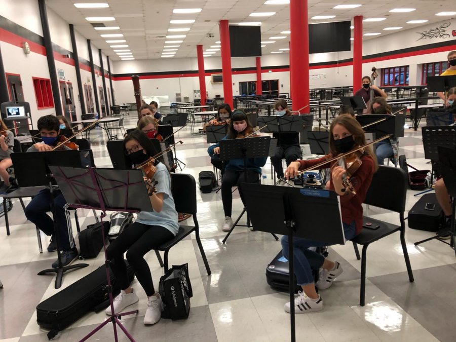 PRACTICE+MAKES+PERFECT%3A+Students+in+the+top+orchestra+get+together+to+practice+at+school.+Students+practice+Tuesdays+after+school+in-person%2C+however+on+other+days+they+practice+virtually.+