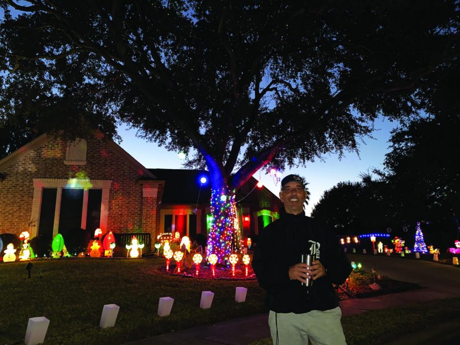 IN FRONT OF HIS DISPLAY:  Baseball coach Sam Degelia poses with his light display in front of his house. Degelia spent six days getting out, setting up all the decorations, and syncing them up with music. “My favorite part of the decorations are when we put music to the lights and watch them move to whatever song is playing,” Degelia said. “The LED lights are really colorful and bright. So these stand out from some of the other lights.” 