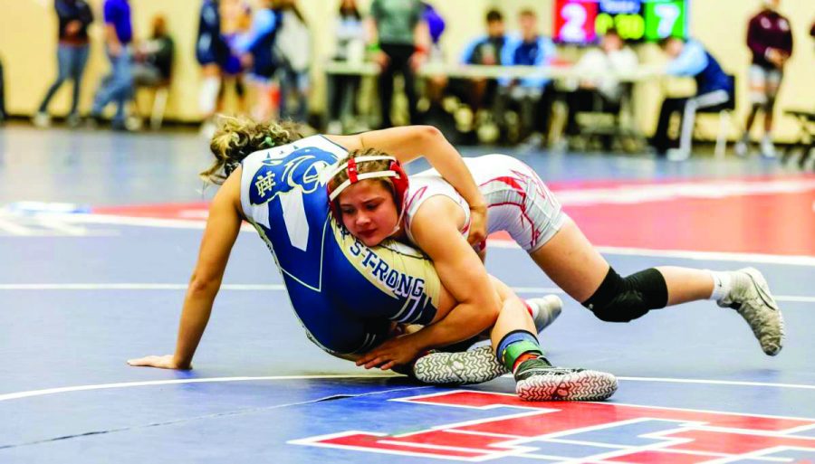 WRESTLED DOWN: Sophomore wrestler Olivia Moreno tackles a wrestler from a different school during a full-day tournament. Moreno has only been wrestling since her freshman year, opposing most of her family members.  