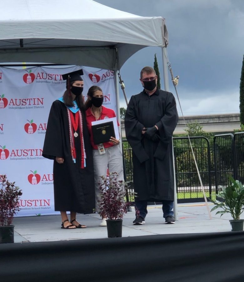 Class of 2020 alumni Emma Davis (left) receives the cover of her high school diploma at the Class of 2020 "Graduation Walk" event alongside her mother and Bowie science teacher Jessica Davis (middle) and Principal Mark Robinson (right). Although she did enjoy the adapted graduation ceremony, Davis expressed her hope that more teachers are allowed to attend the "Graduation Walk" for the Class of 2021 as she believes it would make the event more enjoyable and personable. 