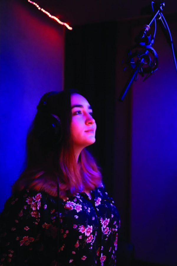 FOCUSED IN: Senior Libby Monahan rehearses her lines into the microphone.  Monahan’s voice acting career is run under her father, who provides advice as a professional vocal artist and  a physical recording studio in their house. PHOTO COURTESY OF Skylar Linscomb