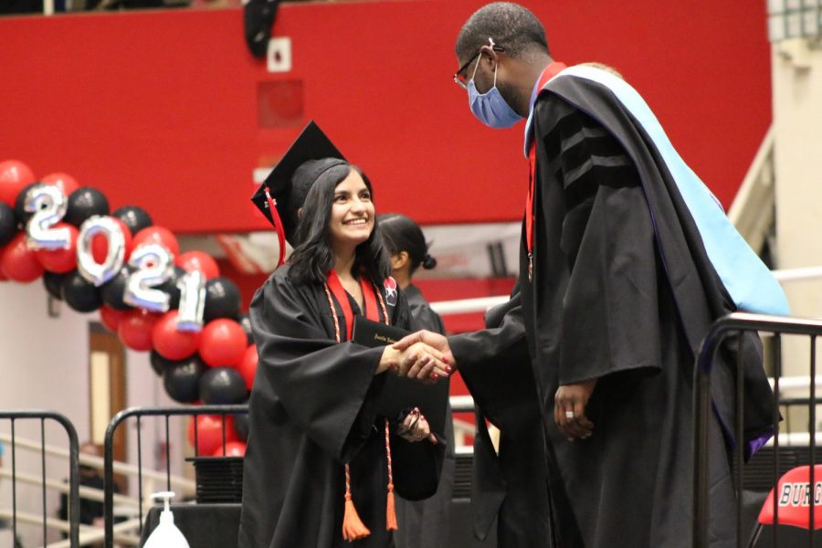 SHAKING HANDS: Katie Martinez shakes the hand of AISD Chief Officer of Schools Dr. Anthony Mays. Martinez’s orange cord represent her taking a college level course through UT OnRamps. “I’m really glad I was part of so many amazing classes that give you a look into the real world,” Martinez said. “I feel like those classes really shaped me into a better person and they prepared me for the world.” 