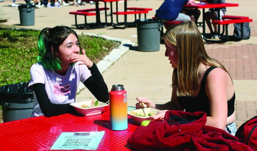 ENJOYING LUNCH: Seniors Kinsey Quintanilla and Reese Wilson distancing maskless during their lunch period. The two seniors spend their time in the courtyard to social distance from large groups.