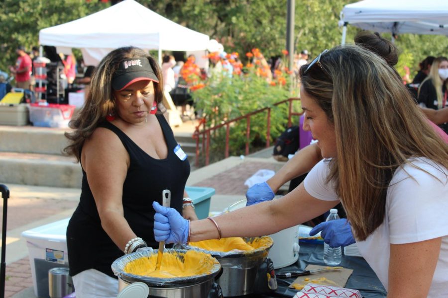 STIRRING IT UP: Volunteers mix cheese for the food stands.