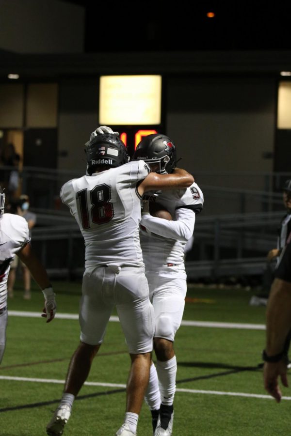 CELEBRATING:  Juniors Aaron Gall and Jacob Kastle hug after Ksatle scored a touchdown. Numerous juniors have been stepping up this year including the new quarterback, Conner Kenyon. “Kenyon came in and has been very consistent,” coach Branyon said. “He’s completing a high percentage of catches, protecting the ball, not turning over the ball, making the right decision, and just overall being efficient.”