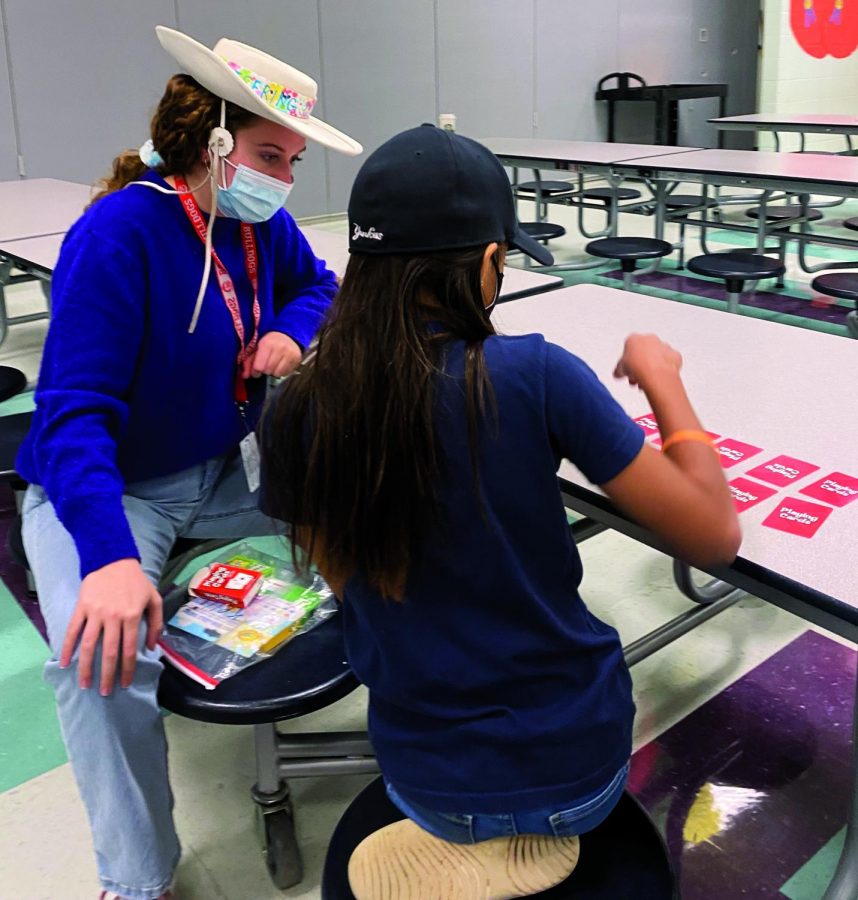 ENGAGING IN GAMES: Senior Kelli Robinson plays card games with her Mills Elementary PALee. The PAL students go every Tuesday and Thursday to local elementary schools.