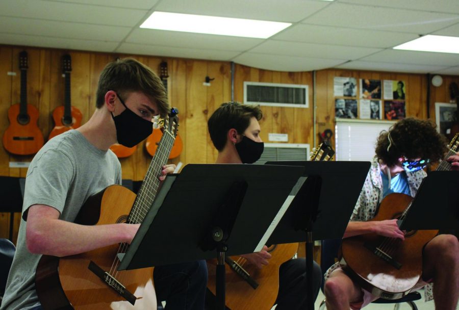 STRUMMING HIS GUITAR: Junior Ethan Smith plays guitar with his other friends in their after school guitar quartet. With the reintroduction of the Music Honor Society, Smith plans to audition as he hopes to be a member of the society.