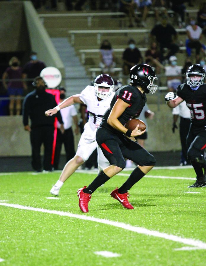 ON THE RUN: Senior quarterback Diego Tello escapes the rush against the Austin High Maroons in the 2020 season. This year, Tello is out of playing due to a collarbone injury. 