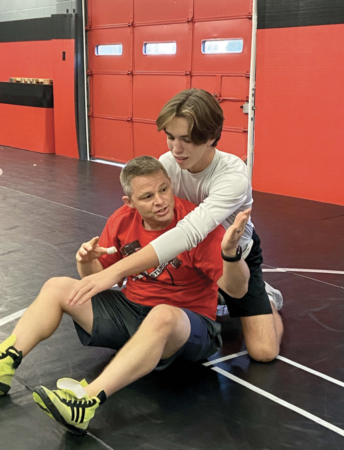GETTING COACHED: Wrestling coach Tyson Dobinsky shows freshman Quinten Joy a technique in practice. The team practices after school Mondays and Wednesdays to prepare for their tournaments. 