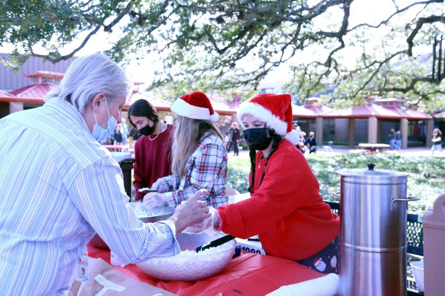 WAY BACK WINTER: Cocoa in hand, Senior Jessie Bowie helps pass out holiday treats to spread the holiday spirit. The event was held for all grade levels and had a hot chocolate bar. 
