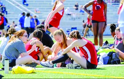 CHATTING AT MEET: Junior Mara Saprautzki sits and talks with her track teammates in between her races. Saprautzki runs as a sprinter in several events at each meet. 