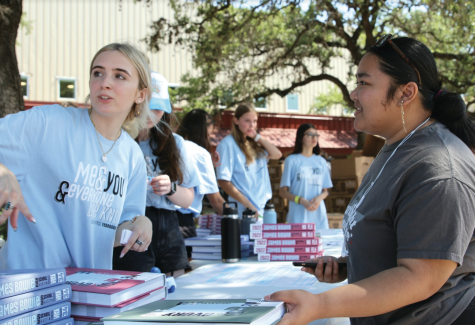 COME GET YOUR BOOK: Editor-in-Chief Lizzie Jensen hands off a yearbook to Ariana Ritzie during the first lunch distribution. This year’s book, similar to year’s in the past, came in three separate colored covers for students to pick from. “I really like the hidden Taylor Swift Easter eggs in the book,” Jensen said. “We named all of our colors used in the book after Taylor Swift albums which can be seen in the Colophon in the back of the book.”