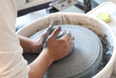 CENTERING THE CLAY: Senior Claudia McCabe works on the first step of throwing clay on a pottery wheel. This step is called centering the clay which ensures that the piece is round and uniform.