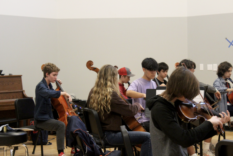 Students practice playing the violin and cello under the direction of choir director Joseph Smith.