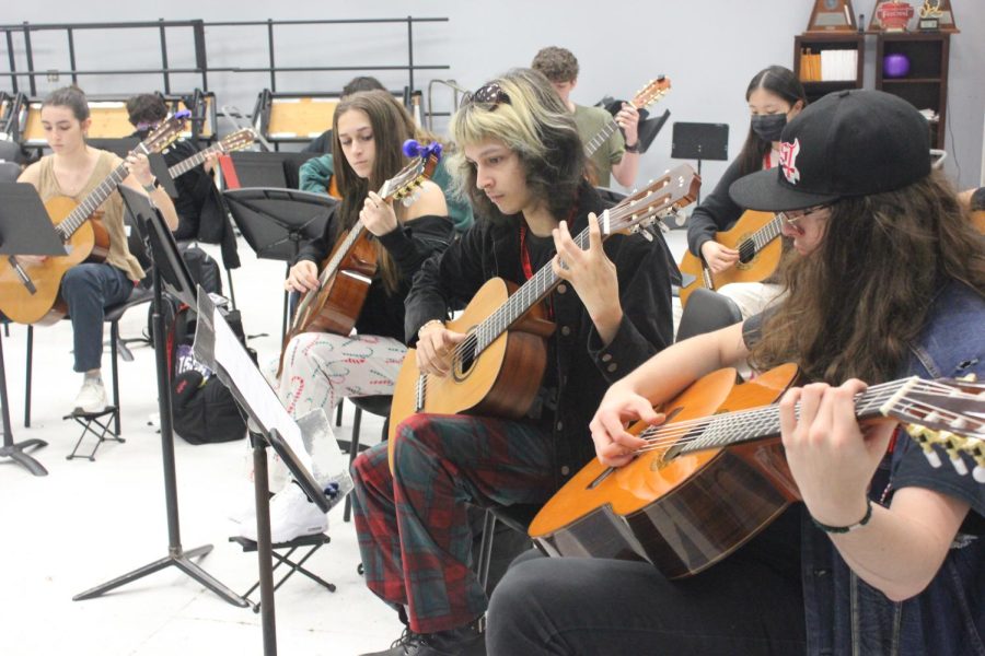 STRUMMING WITH INTENT: Guitar students practice during their class period. The students spent many class periods preparing for region auditions.