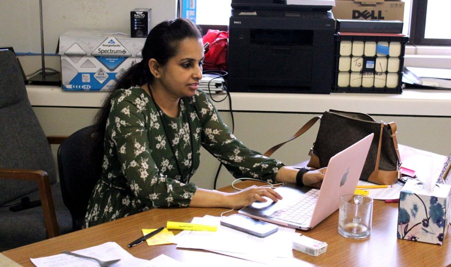Substitute teacher Mahalak Shmi works at her desk while standing in for Special Education teacher Patrick Howe.