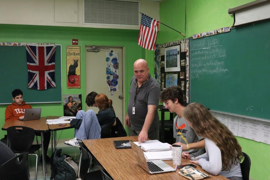 ASSISTING A STUDENT: Social studies teacher Charles Stampley enlisted himself into the U.S. Navy at the young age of 18 and retired as a major. The years spent in the military have given Stampley an awareness of other cultures, and he incorporates this knowledge into his everyday teaching. 